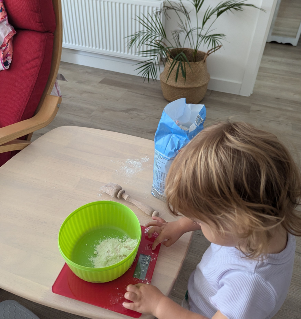 bambina che pesa la farina. le attività di vita quotidiana aiutano a migliorare l'austostima dei bambini